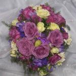 This beautiful mid-summer bouquet of Cool Water Roses, 
Creamy Eden Spray Roses,
deep purple Lisianthus, lavender Stock  and Freesia
are delicately mixed with soft deflexus fern.